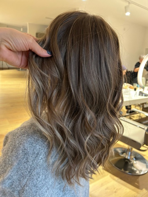 Frau streicht sich die Haare hinters Ohr.